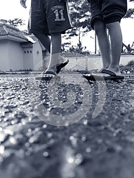 Two boys Walking at asphalt with sandals