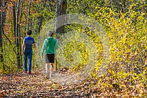 Two Boys Walking through Autumn Forest