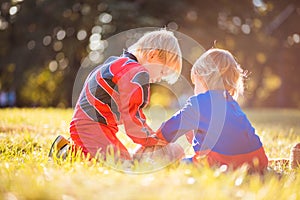 Two boys wearing Halloween suits playing on the grass