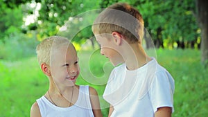 Two boys in white clothing standing in the park