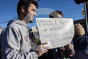 Two boys who are part Middle Eastern and part American hold sign saying Don`t send me to kill my own peopl