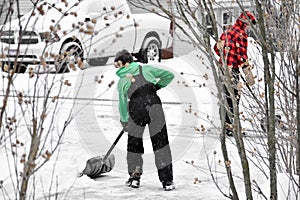 Two Boys Working Together Shoveling Driveway