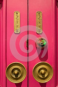 Two brass doorknobs on a bright red door photo