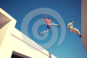 Two brave men jumping over the roof photo