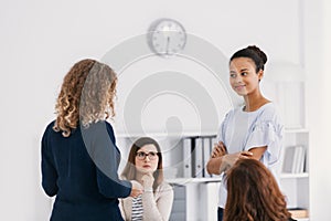 Two brave women standing and looking at each other during role paying at psychotherapy support meeting