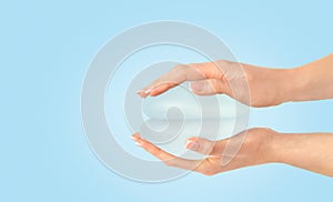 Two breast implants in hands on blue background , copy space.