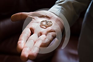 Two bridal wedding rings on groom`s hand, close up