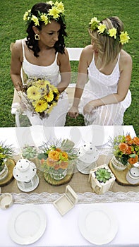 Two bridesmaids looking at each other after catching the bouquet. Two lesbian brides on their wedding day