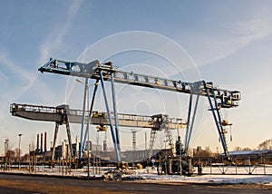 Two bridge crane against a blue sky