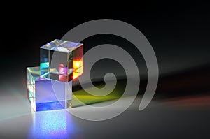 Two bright luminous prism cubes refract light in different colors photo