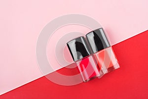 Two bright red and pink nail polish bottles