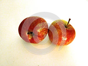 Two bright ripe red apples isolated on a light background