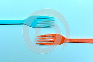 Two brightly colored forks facing towards each other on a ktchen table in retro style