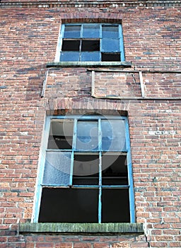 Two broken windows derelict brick building
