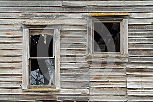 Two Broken Windows in a Dilapidated Wooden House