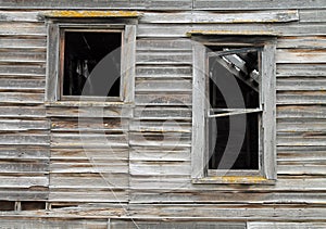 Two Broken Windows in a Dilapidated Wooden House