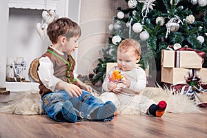 Two brothers in anticipation of Christmas at the Christmas tree