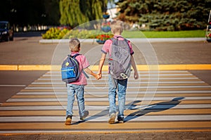 Two brothers with backpack walking, holding on warm day on the