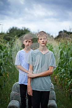 Two brothers in a field in the countryside with green plants maize