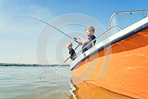 Two brothers on a fishing trip caught a fish.Fishing on the lake from a boat. Fishing rest concept.