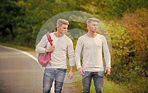 two brothers go adventure. friendship concept. men hitch hiking. man casual style travel with backpack. traveler