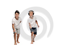 Two brothers looking at camera and dancing while listening music in headphones