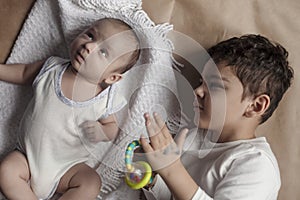 Two brothers lying and posing. Portrait of brothers. Two months baby boy and five years small boy playing cheerfully. View from