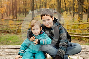 Two brothers play outdoors in autumn, best friends. Two happy boys