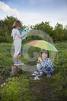 Two brothers play in rain outdoors