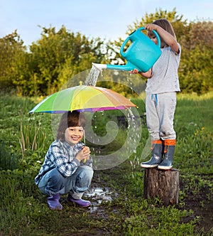 Two brothers play in rain outdoors