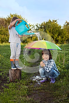 Two brothers play in rain outdoors