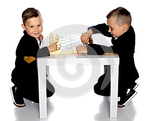 Two little boys play chess.