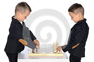 Two little boys play chess.