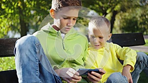 Two brothers playing video game for children on mobile phone
