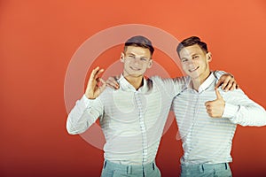 Two brothers showing thumbs up and ok gestures