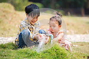 Two brothers and sisters play water from the tap