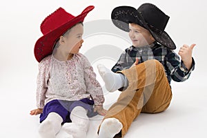 Two brothers smiling wearing cowboy hats isolated