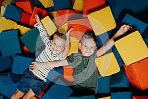 Two brothers spending time in multi-color soft cube pool in entertainment center