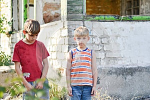 Two brothers are standing near a burned-out house, who lost thei