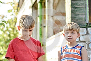 Two brothers are standing near a burned-out house, who lost thei