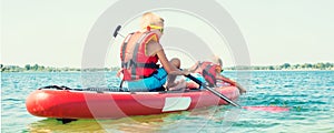 Two brothers swimming on stand up paddle board.Water sports , active lifestyle.