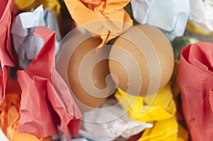 Two brown Easter eggs on crumpled colorful paper. Close-up. Sweet easter concept. Healthy food. Flat lay, top view