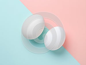 Two brown eggs sit next to each other on a white background