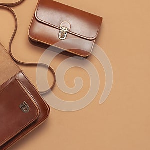 Two Brown leather women bag on brown beige background top view flat lay copy space. Fashionable women`s accessories. Sales Fashio