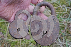 two brown old rusty iron padlocks lie on the palm