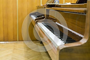 Two brown pianos in the music class. Close up of piano keys at classroom