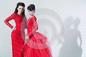 Two brunette girlfriends wearing red dresses