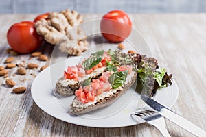 Two bruschettas, ginger, almonds and tomatoes