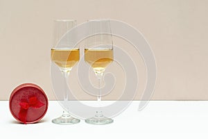 Two bubbly champagne glasses and red box as gift on white background with copy space. Valentines day, love, birthday