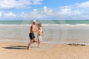 Two buddy runners jogging outdoor on summer tropical island beach with blue sea, couple doing exercise outdoor, sport man and